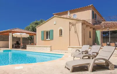 a villa with a swimming pool in front of a house at Awesome Home In Saint Didier in Saint-Didier