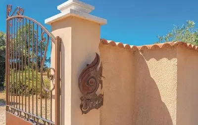 a fence with a iron gate with a dragon on it at Awesome Home In Saint Didier in Saint-Didier