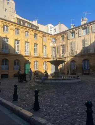 a building with a fountain in the middle of a courtyard at Studio coeur de ville, rue Papassaudi in Aix-en-Provence
