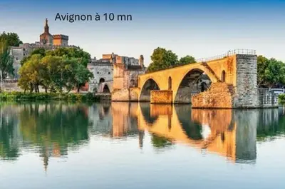 a bridge over a river with a city in the background at Joli appartement centre village au calme in Châteaurenard