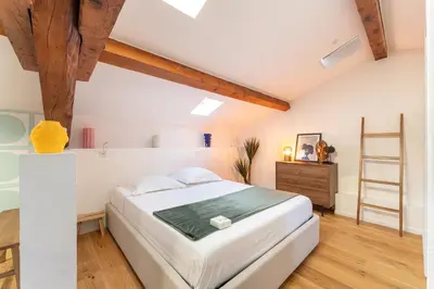 a bedroom with a large white bed and a wooden floor at Design & Cozy, 10 meters from Cours Mirabeau, AC in Aix-en-Provence