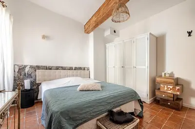 a bedroom with a large bed in a room with white walls at Exceptional apartment in Aix-en-Provence