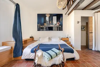 a bedroom with a bed with a blue comforter at Exceptional apartment in Aix-en-Provence