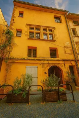 a yellow building with two benches in front of it at Exceptional apartment in Aix-en-Provence