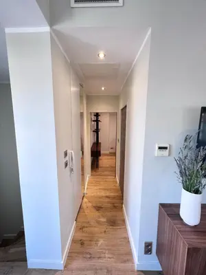 a hallway with white walls and wood floors at La Terrasse, 2 chambres, hyper centre in Aix-en-Provence