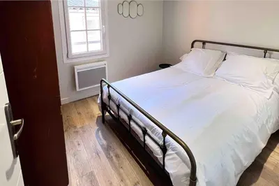 a bedroom with a bed with white sheets and a window at La Terrasse, 2 chambres, hyper centre in Aix-en-Provence