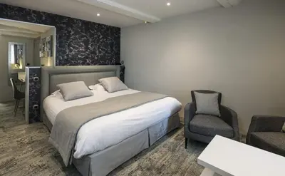 a bedroom with a large bed and a chair at Le Mas de Guilles in Lourmarin