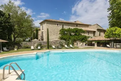 a large swimming pool in front of a building at Le Mas de Guilles in Lourmarin