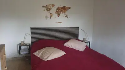 a bedroom with a red bed with two pillows at Petite maison sur Apt in Apt