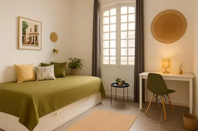 a bedroom with a bed and a desk and a window at Cozy et elegant studio Aix en Provence centre in Aix-en-Provence