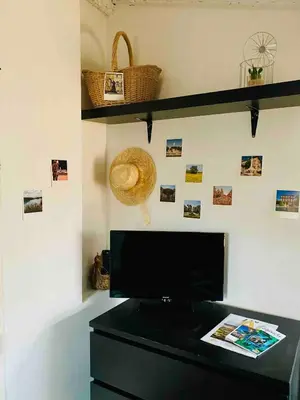 a black dresser with a hat on a wall at Cocon cosy et calme au coeur du centre historique in Aix-en-Provence