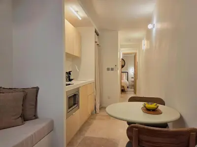 a small living room with a table and a kitchen at Logement elegant avec patio prive et climatisation in Aix-en-Provence