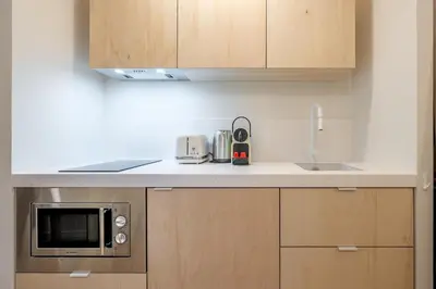a kitchen with a counter top with a microwave at Logement elegant avec patio prive et climatisation in Aix-en-Provence