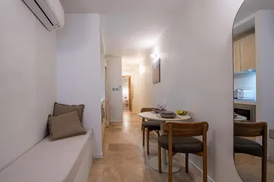 a living room with a table and chairs in a room at Logement elegant avec patio prive et climatisation in Aix-en-Provence