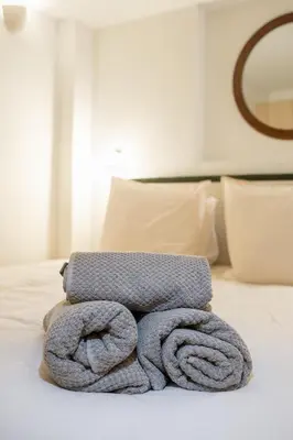 a pile of towels sitting on top of a bed at Logement elegant avec patio prive et climatisation in Aix-en-Provence