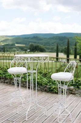 a white table and two chairs on a wooden deck at Domaine de la barbeirasse in Céreste