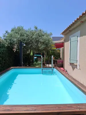 a large blue swimming pool next to a house at Villa Figlio en Provence avec petite piscine in Châteaurenard