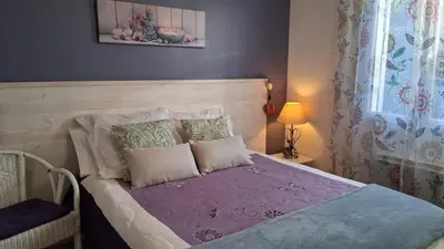 a bedroom with a bed with purple sheets and pillows at Villa Figlio en Provence avec petite piscine in Châteaurenard