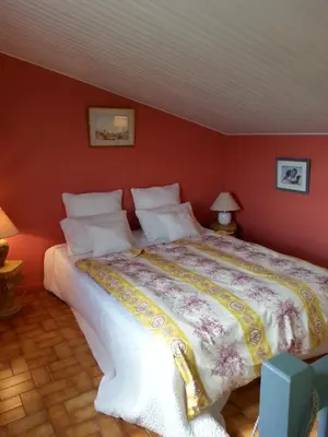 a bedroom with a large bed with red walls at La Petite Maison de Marie Louise in Lauris