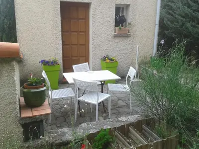 a patio with a table and chairs in front of a house at La Petite Maison de Marie Louise in Lauris