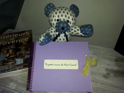 a teddy bear sitting on top of a purple notebook at La Petite Maison de Marie Louise in Lauris