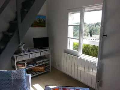 a room with a staircase with a television and a window at La Petite Maison de Marie Louise in Lauris