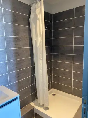 a shower with a white shower curtain in a bathroom at Hôtel La Lavande in Carpentras