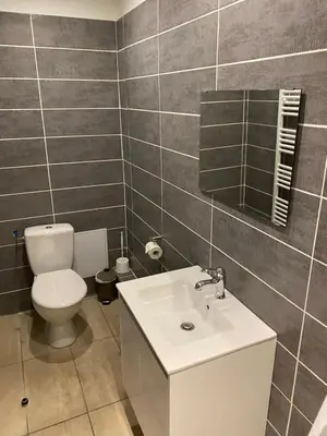 a bathroom with a white toilet and a sink at Hôtel La Lavande in Carpentras