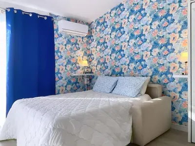 a bedroom with a bed with a floral wallpaper at Tiny house Cécile en Avignon in Avignon