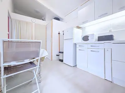 a kitchen with white appliances and a table in it at Tiny house Cécile en Avignon in Avignon