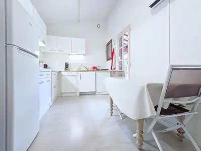 a white kitchen with a table and a refrigerator at Tiny house Cécile en Avignon in Avignon