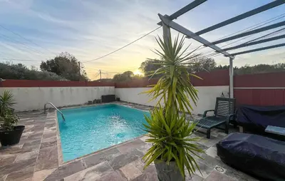 a swimming pool with a chair and a palm tree at Cozy Home In Miramas With Outdoor Swimming Pool in Miramas