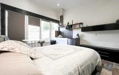 a bedroom with a large bed and a kitchen at Cozy Home In Miramas With Outdoor Swimming Pool in Miramas