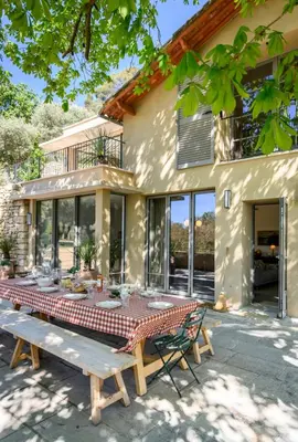 a picnic table in front of a house at Le Hameau des Sources Lourmarin Luberon in Lourmarin