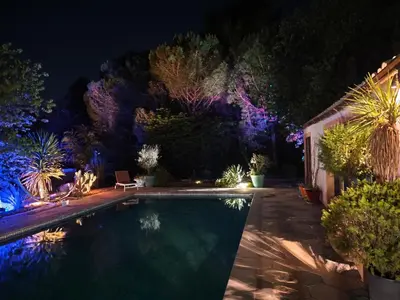 a swimming pool in a garden at night at mas alpilles in Eyguières