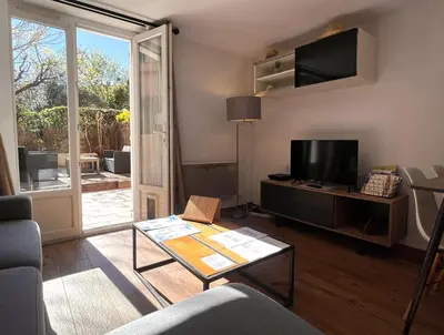 a living room with a couch and a tv at Le Breizh'Aix - Joli duplex au cœur du centre ville d'Aix-en-Provence avec jardin in Aix-en-Provence