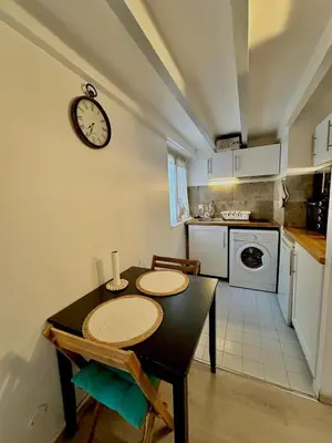 a kitchen with a table and a clock on the wall at Perle Aix en Provence centre ville in Aix-en-Provence
