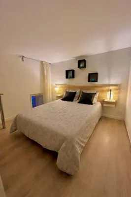 a bedroom with a large bed with two monitors on the wall at Perle Aix en Provence centre ville in Aix-en-Provence