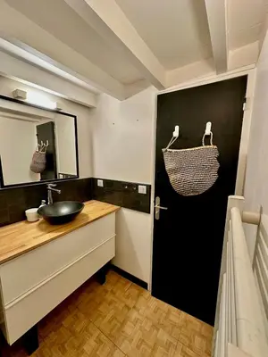 a bathroom with a sink and a black door at Perle Aix en Provence centre ville in Aix-en-Provence