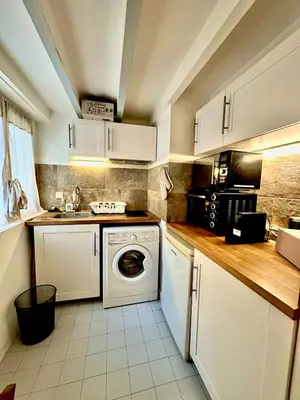 a kitchen with white cabinets and a washing machine at Perle Aix en Provence centre ville in Aix-en-Provence