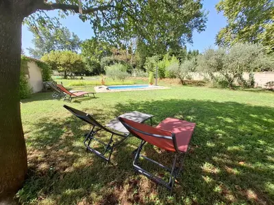 two chairs sitting in the grass under a tree at Ginette et Marcel la maison in Saint-Rémy-de-Provence
