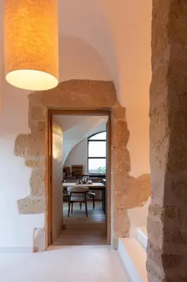 an open doorway into a dining room with a stone wall at Domaine Arterra I Parc privé, Piscine & Tennis in Lauris