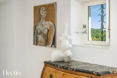a white statue sitting on a table next to a window at Domaine Arterra I Parc privé, Piscine & Tennis in Lauris