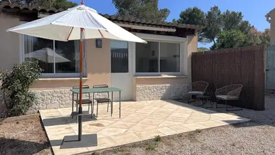 a patio with a table and an umbrella at Studio en Provence in Cheval-Blanc