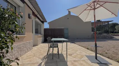 a table and two chairs and an umbrella on a patio at Studio en Provence in Cheval-Blanc