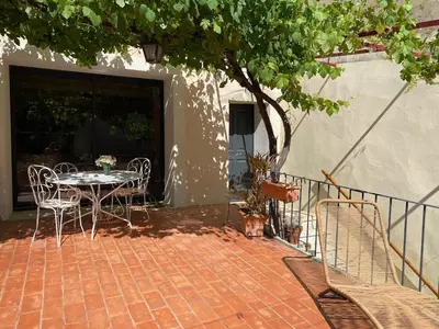 a patio with a table and chairs and a tree at Casa Poli, maison de village avec terrasse in Eyguières