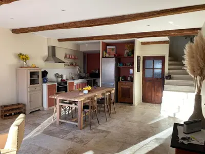 a kitchen with a wooden table and chairs in a room at Casa Poli, maison de village avec terrasse in Eyguières