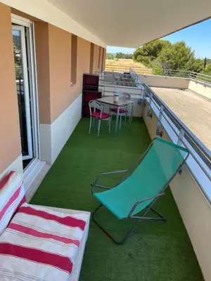 a balcony with a chair and a table and chairs at Charmant appartement hotel calme à Aix en Provence in Aix-en-Provence
