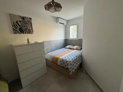 a small room with a white cabinet and shelves at Charmante Maisonnette T3 avec Jardin Privé in La Motte-dʼAigues