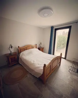 a bathroom with a wooden door and a sink at La propriété de Nans in Grans